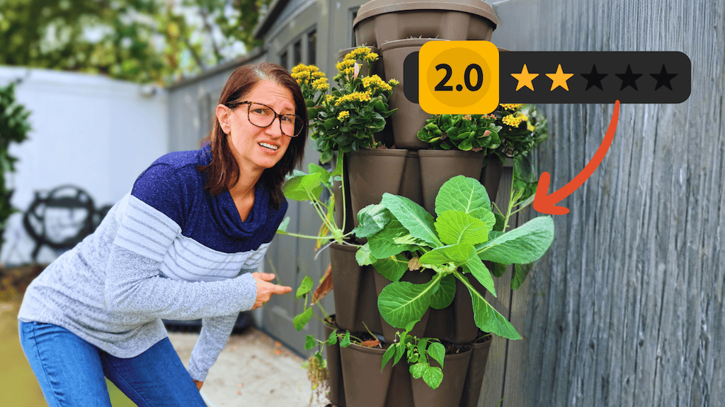woman pointing towards a Greenstalk vertical planter with several different plants in it with a graphic of 2.0 out of 5.0 stars
